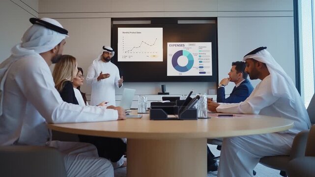 Corporate business event with emirati and western business people professionals participating in a corporate meeting, an executive giving a presentation using a large screen, discussing new strategies