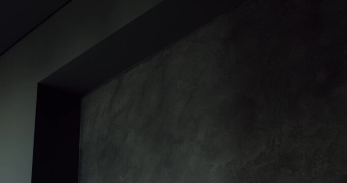Dark gray wall meets a darker gray ceiling in a modern, minimalist interior. The smooth textures and clean lines create a sophisticated and dramatic atmosphere.