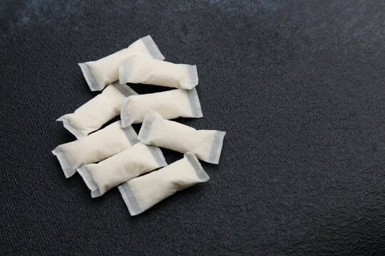 Different types of snus pouches for nicotine consumption on a dark surface