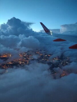 Vue a&eacute;rienne nocturne depuis un avion au-dessus des nuages et lumi&egrave;res urbaines &ndash; easyjet 