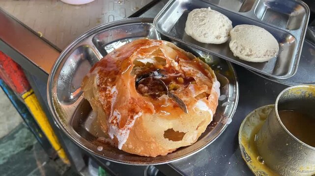 Indian style Raj Kachori prepared with curd and bhujia; professional food photography of a traditional royal chaat platter served in a sweet shop or restaurant setting.