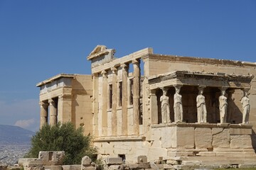 Obraz premium The Erechtheion, an ancient Greek temple on the north side of the Acropolis in Athens renowned for its Porch of the Caryatids, featuring six sculpted female figures serving as supporting columns