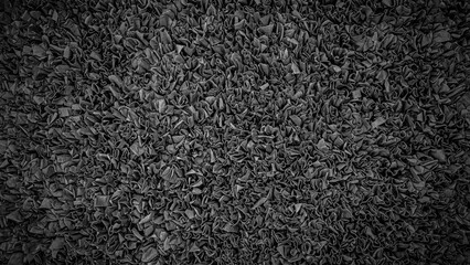 Fototapeta premium Close view of a textured surface made of fabric in a dark color showing folds and wrinkles in an abstract design