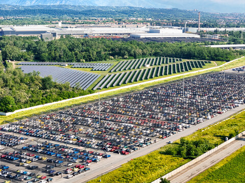 Aerial view of the large car storage lot and solar panel arrays at the industrial plant in Rivalta di Torino, Piedmont, Italy.