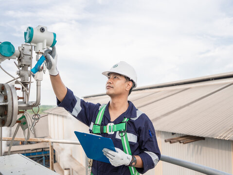 Professional engineers checklist monitor industrial air pollution reduction on exhaust pipe. Engineering Asian working analysis environment protection digital scene for concept sustainable energy. ESG