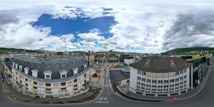 Aerial view of the historic city center featuring ornate rooftops, urban streets, and surrounding hills under a cloudy sky in Biel Bienne, Canton of Bern, Switzerland.