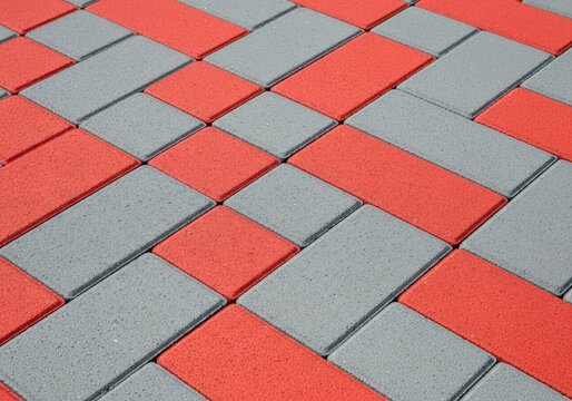Close-up view of interlocking red and gray rectangular brick pavers creating a geometric pattern on an outdoor walkway surface, backdrop, texture, background