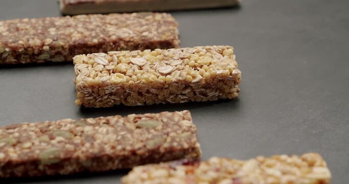Close-up of assorted granola bars on a dark background, showcasing variety and texture. Ideal for healthy snacking, fitness, and nutrition concepts. Assorted Energy Bars On Dark Background