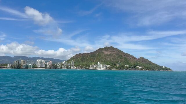 View of Diamond Head crater and the Gold Coast from a sailboat off Waikiki Beach in Honolulu on the island of Oahu in Hawaii. 
