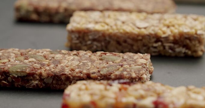 Close-up of assorted granola bars on a gray background. Healthy snack options made from oats, seeds, and nuts. Perfect for on-the-go nutrition and energy boosting. Close-Up of Nutrious Granola