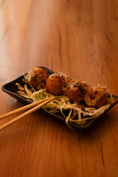 Close up of takoyaki with chopsticks on table