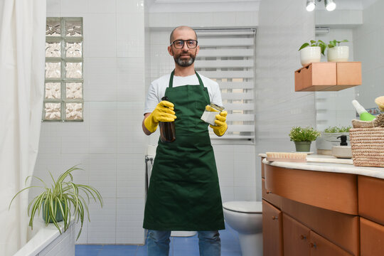 Hispanic man cleaning bathroom with eco friendly products
