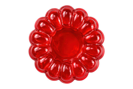 Glossy red gelatin dessert mold isolated on light gray background, top view with retro party food styling and vibrant translucent texture