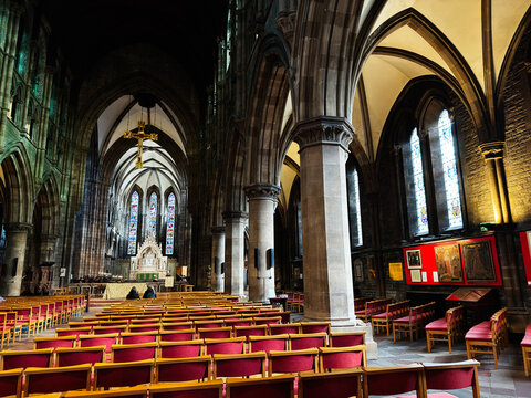 Interior of historic St Mary's Episcopal Cathedral church in Edinburgh, Scotland, UK with vaulted arches, stained glass windows, wooden pews and ornate altar
