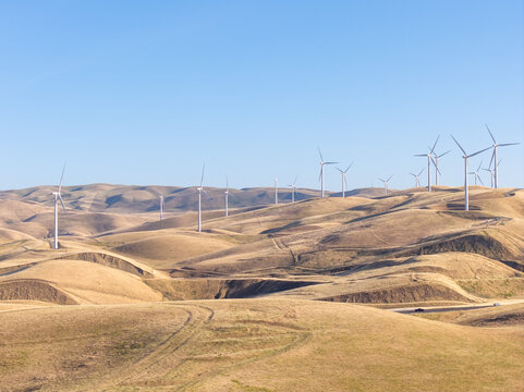 Wind turbines generating clean electricity on rolling hills in Altamont Pass, California, symbolizing sustainable power and a green future for the environment