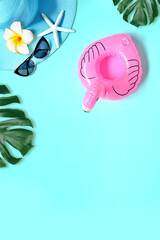 Obraz premium Tropical summer beach background. Palm trees branches, hat with starfish and flamingo on blue summer background. Summer concept.