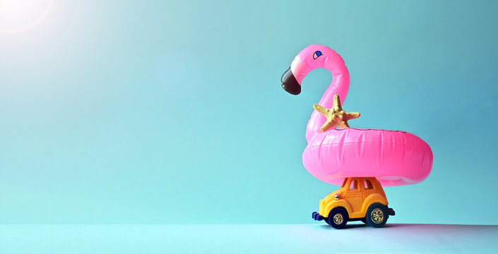 Pink inflatable flamingo on toy car and starfish. Summer pool float party idea. Summer concept.
