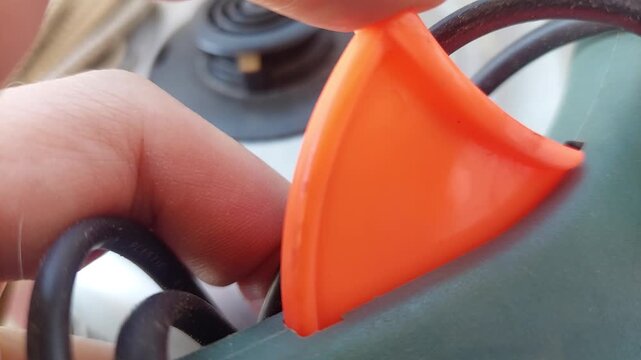 Person pressing the trigger of a hot glue gun