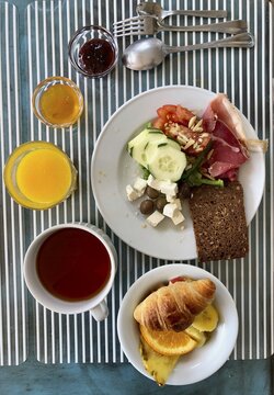 Set table with breakfast for one person, with bread, ham, vegetables, cheese, jam and muesli, Portugal