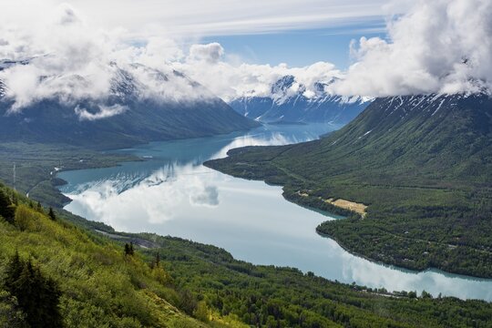 View of snowy mountains in spring and turquoise Kenai Lake with reflection, Slaughter Ridge Trail, Cooper Landing, Kenai Peninsula, Alaska, USA
