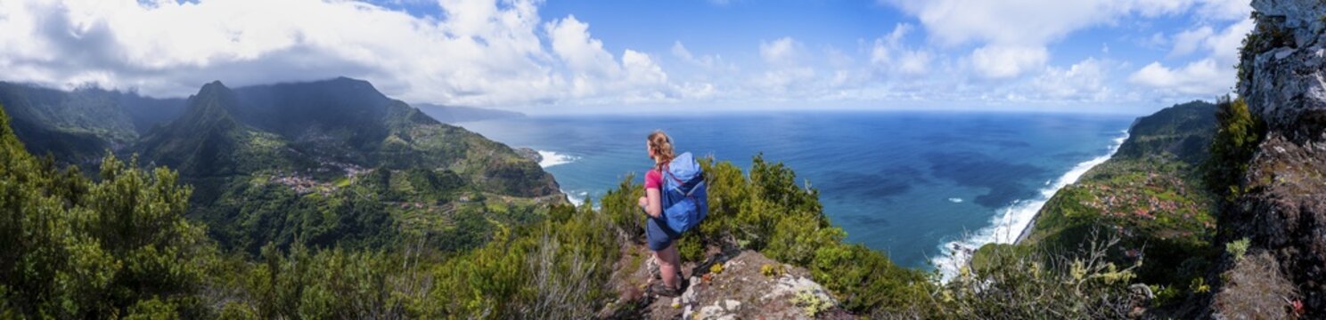 Hiker on the ridge of Pico do Alto, view over coastal landscape and steep cliffs, Madeira, Portugal