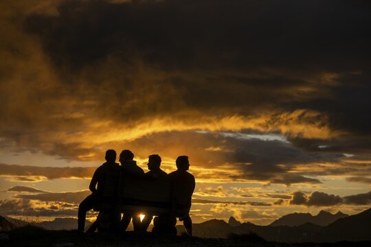 People marvelling at Montafon mountains with dramatic cloudy sky at sunset, Tschagguns, R&auml;tikon, Montafon, Vorarlberg, Austria