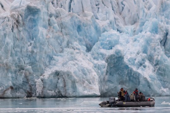 Dinghy with tourists in front of the glacier edge of Monacobreen, Liefdefjord, Woodfjord area, Spitsbergen Island, Svalbard and Jan Mayen archipelago, Norway
