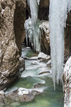 Path to Partnach wild river in the Partnach gorge with long icicles and snow in winter, near Garmisch-Partenkirchen, Upper Bavaria, Bavaria, Germany