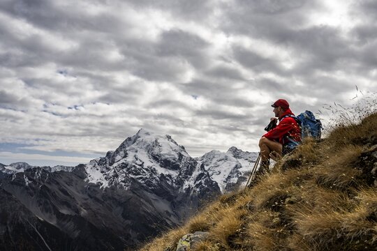 Mountaineer on autumnal mountain meadow with cloudy sky in front of Ortler summit massif, Trafoier Tal, Merano, Vinschgau, South Tyrol, Italy