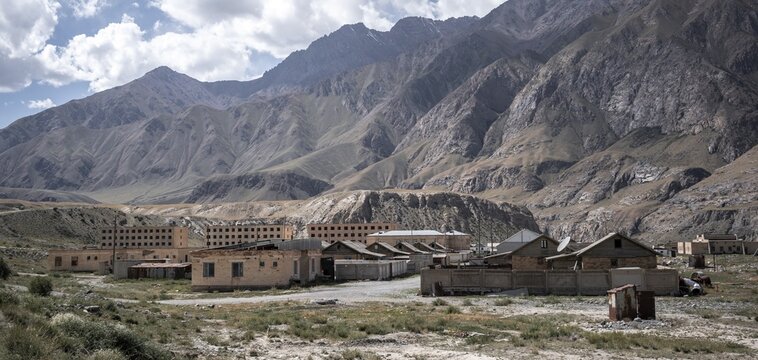 Abandoned buildings in a barren landscape, ghost town of Enilchek in the Tien Shan Mountains, Ak-Su, Kyrgyzstan