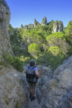 Woman with hiking backpack in the rock labyrinth of Mour&egrave;ze, D&eacute;partement H&eacute;rault, France