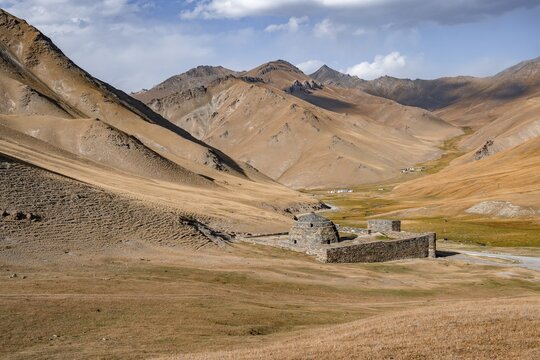 Historic caravanserai Tash Rabat from the 15th century, with yellow hills, Atbashy district in the Naryn region, Kyrgyzstan