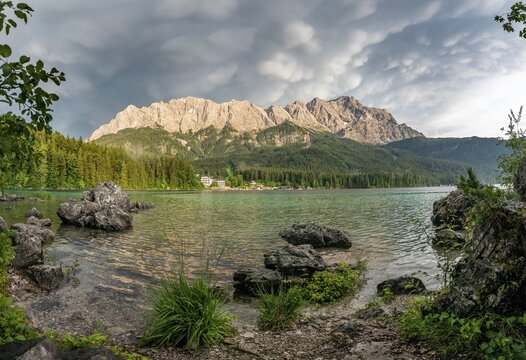 Rocks on the shore, Lake Eibsee lake in front of Zugspitze massif with Zugspitze, dramatic Mammaten clouds, Wetterstein range, near Grainau, Upper Bavaria, Bavaria, Germany