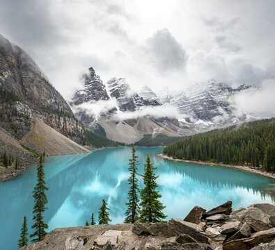 Cloudy mountain peaks, reflection in turquoise glacial lake, Moraine Lake, Valley of the Ten Peaks, Rocky Mountains, Banff National Park, Alberta Province, Canada