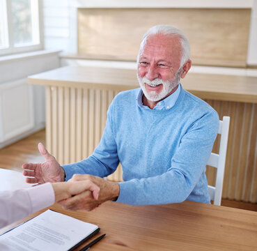 Happy senior old man or businessman client make financial insurance estate business deal contract signing and shaking hands, agent lawyer, satisfied mature customers signing contract meeting bank mana
