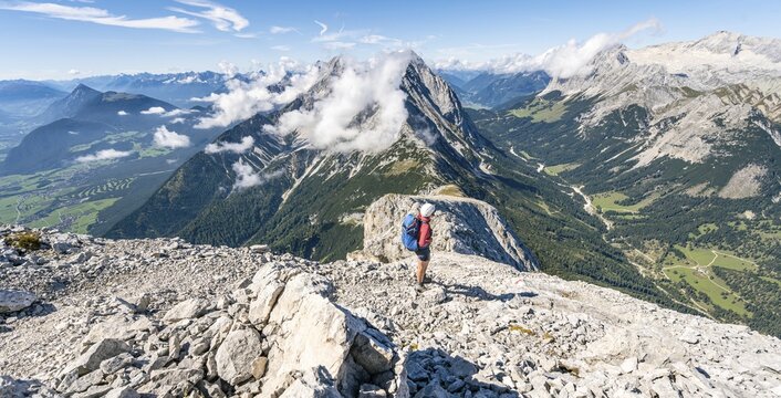 Hiker with climbing helmet on a steep hiking trail, ridge walk, Hohe Munde, Mieminger Mountains, Tyrol, Austria