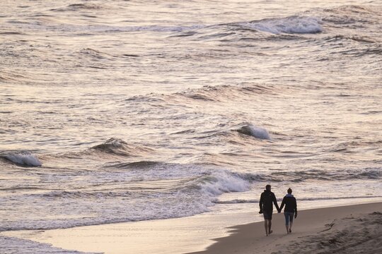 Couple walking by the sea, surf, S&oslash;ndervig Strand, North Sea, Denmark