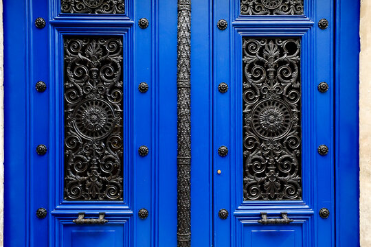 Ornate blue Paris double door with black ironwork