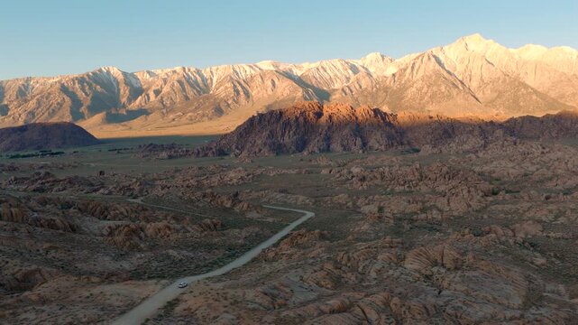 Alabama Hills California - High Aerial Approach Over Road Towards Mt Whitney at Sunrise with Morning Light on Mountains