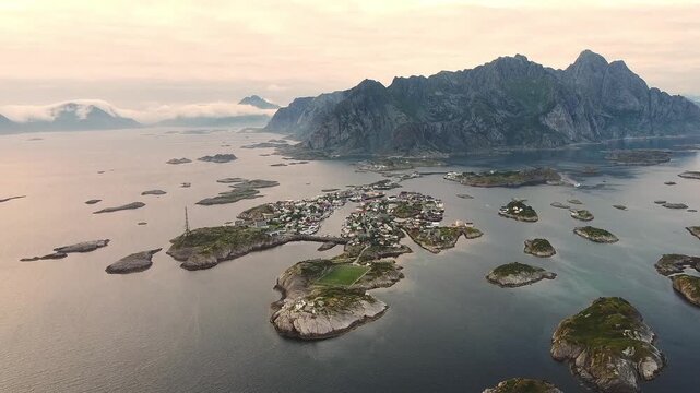 Drone orbit flight over water around Henningsv&aelig;r island village center, Lofoten Islands Norway aerial cinematic