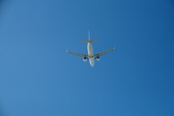 Fototapeta premium White Airplane Taking Off into Clear Blue Sky, Low Angle View