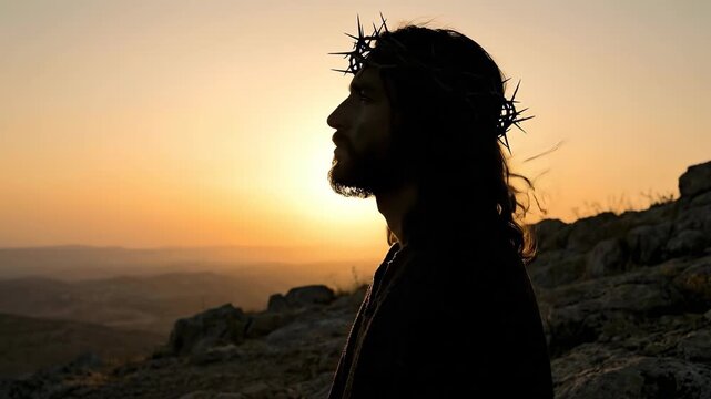 Jesus Christ with crown of thorns standing on hilltop at sunset. Silhouette of man praying at dusk. Religious concept of faith, sacrifice, and divine light.