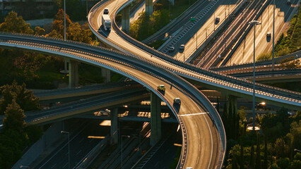 Complex road infrastructure featuring a multi-level highway interchange with many vehicles traveling on various bridges and ramps, highlighting modern connectivity and the flow of traffic © Nasos Zovoilis