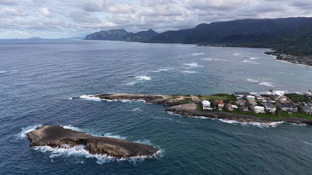 Still shot of Laie Point with waves breaking and the Koolau mountain range in the background in northeastern Oahu in Hawaii. 