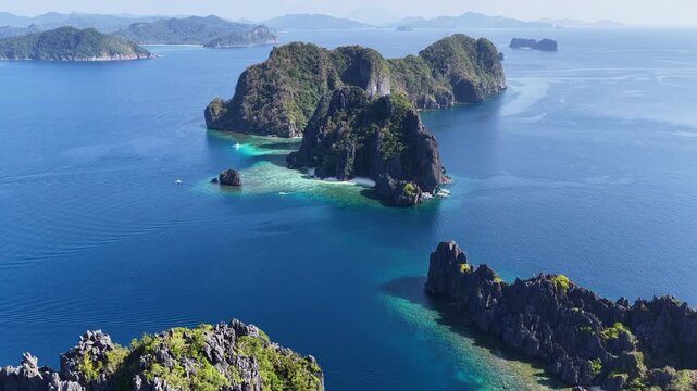 Dramatic limestone islands rise in Bacuit Bay, El Nido. This scenic area in the Philippines is a popular vacation destination due to its beautiful coral reefs, beaches, and hidden lagoons.