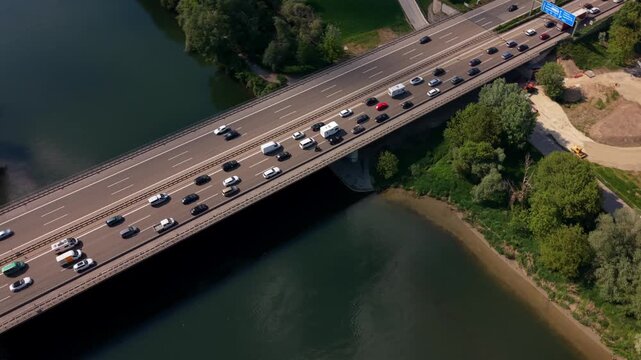 Autobahnbruecke Donau near Ingolstadt is packed with slow moving vehicles due to lane closures. Drone footage highlights contrast between heavy traffic and the calm river landscape of Upper Bavaria.