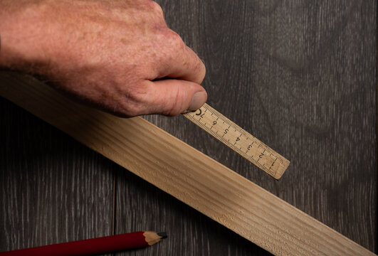 Carpenter Measuring Wooden Board With Folding Rule