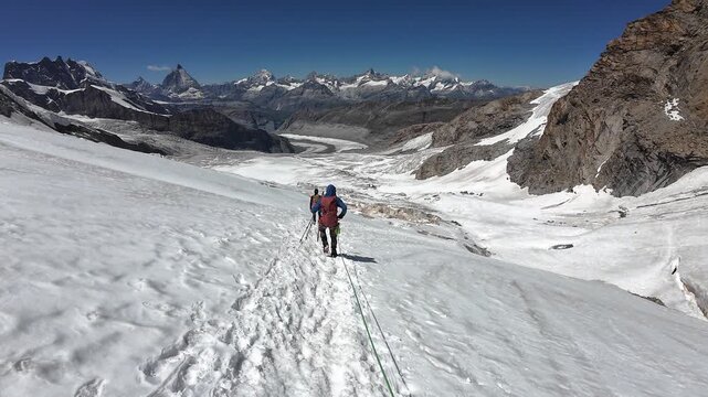 POV mountaineering in rope team on glacier Grenzgletscher and mountain panorama with summits Breithorn, Matterhorn, Dent Blanche, Zinalrothorn and Weisshorn in Pennine Alps, Switzerland