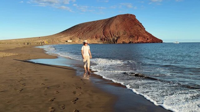 man walking near Atlantic ocean at el Medano Tenerife, Spain