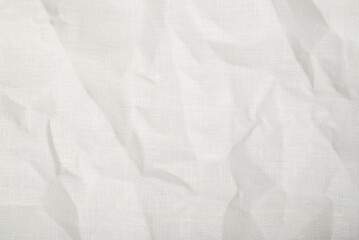 Fototapeta premium Wrinkled white canvas fabric texture with visible woven pattern and soft folds. Clean textile background for mockups, branding and minimal design projects.